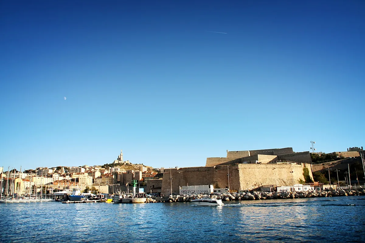 Port mediterrani amb el dic i la ciutat al fons