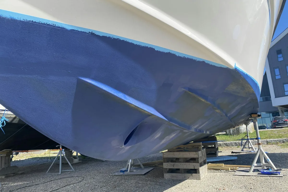 Obra viva acabada de pintar en un vaixell apuntalat sobre falques